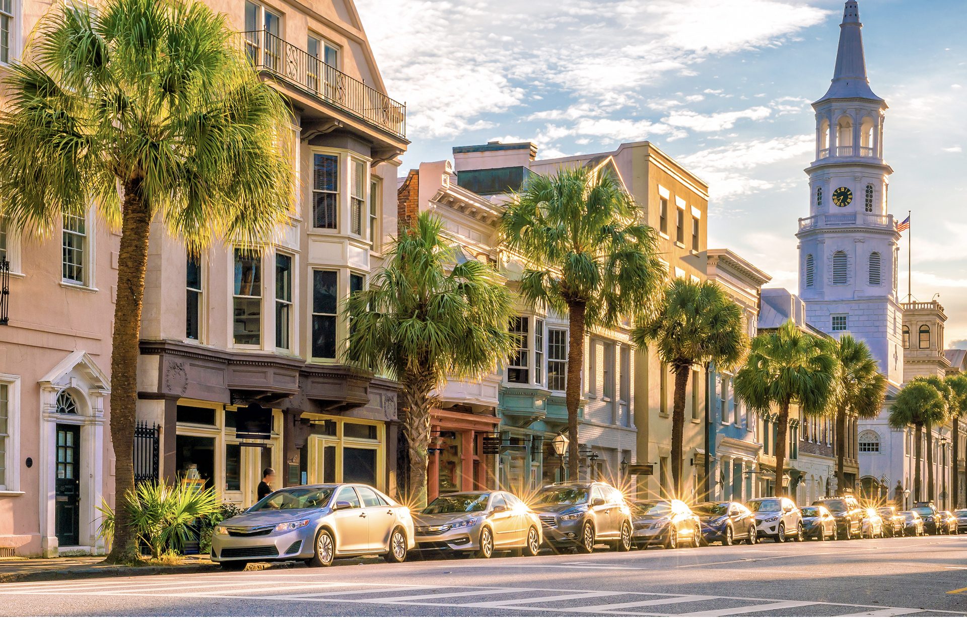 Historic street in Charleston, South Carolina, lined with palm trees and a church steeple